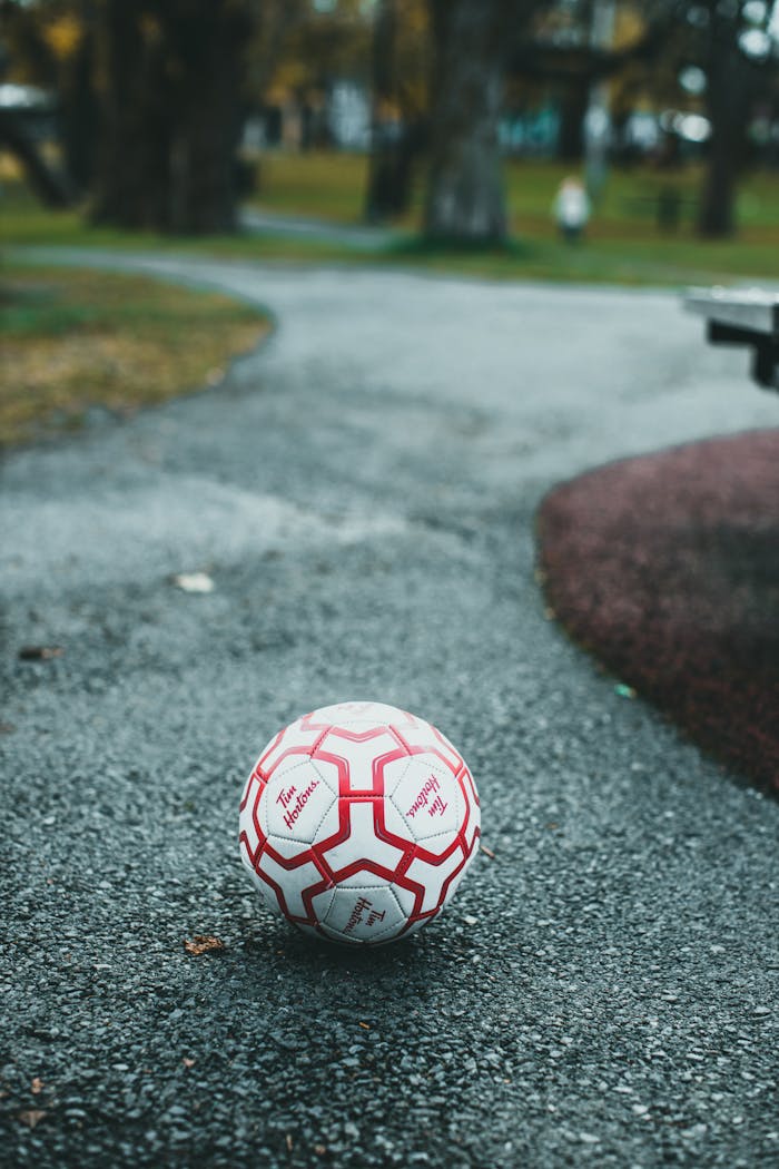 White and Red Soccer Ball on Gray Concrete Floor